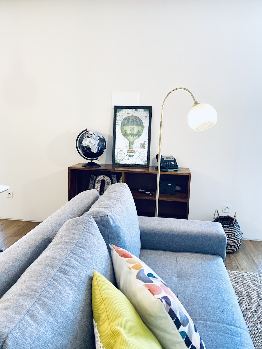 Light-filled seating area with sofa and wall-mounted television
